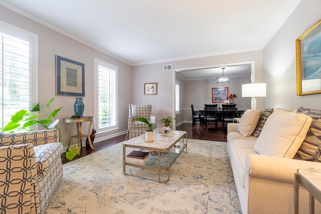 living room featuring wood-type flooring, crown molding, and a chandelier