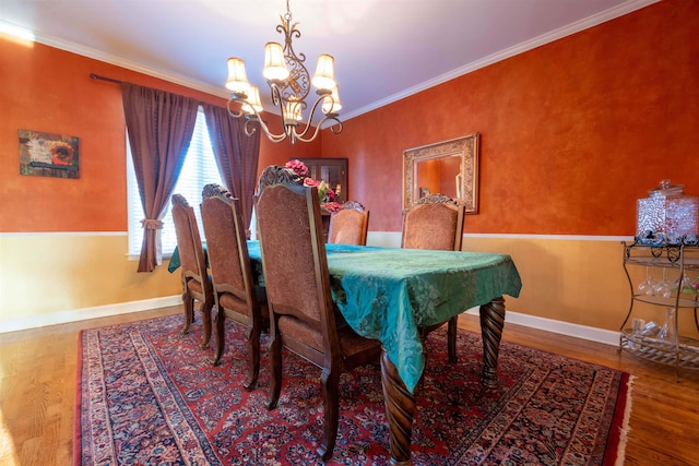 dining room with hardwood / wood-style flooring, crown molding, and a notable chandelier