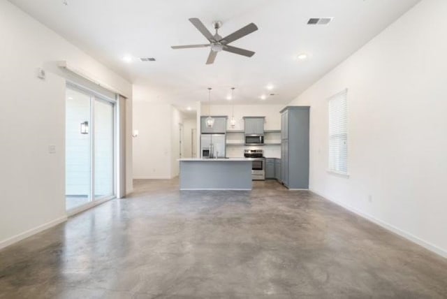 unfurnished living room featuring concrete flooring, plenty of natural light, and ceiling fan