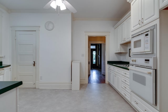 kitchen with ceiling fan, ornamental molding, white appliances, and white cabinetry