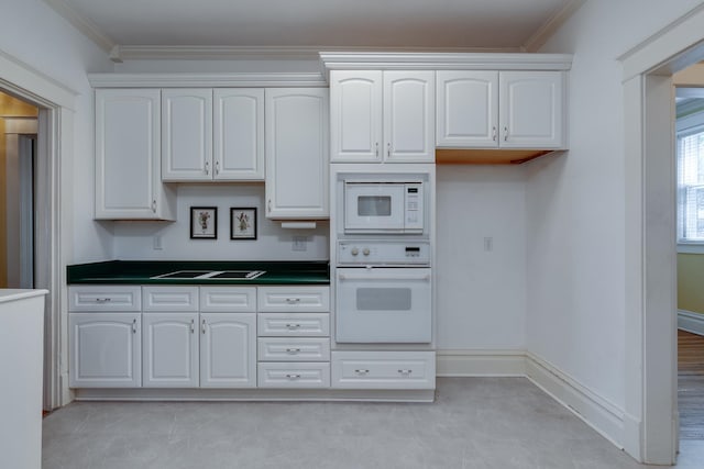 kitchen featuring ornamental molding, white cabinets, and white appliances