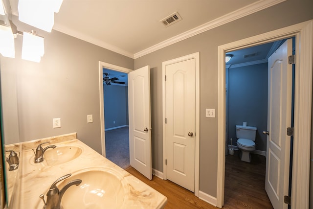 bathroom featuring vanity, crown molding, hardwood / wood-style floors, and toilet