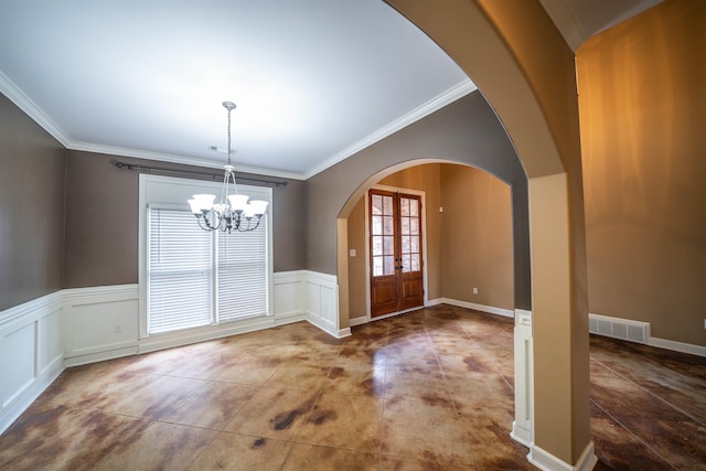 foyer entrance featuring an inviting chandelier, ornamental molding, and french doors