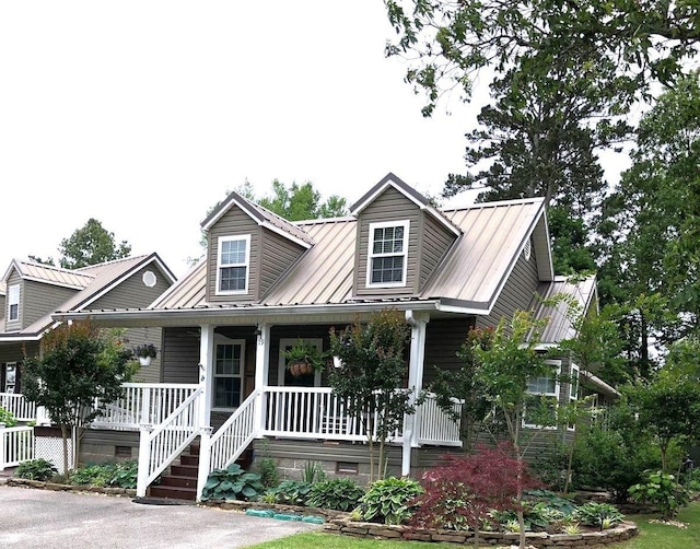 cape cod house featuring covered porch, metal roof, and crawl space