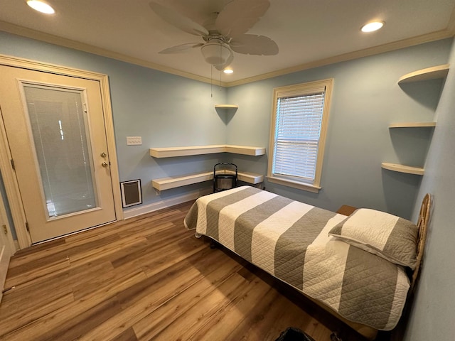 bedroom featuring built in desk, crown molding, hardwood / wood-style floors, and ceiling fan