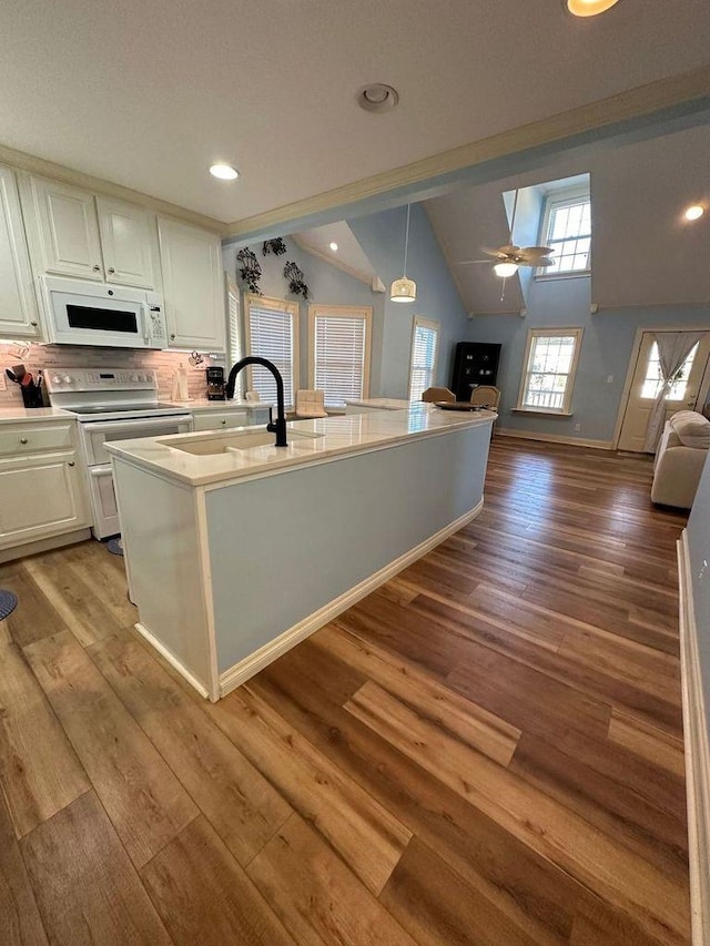 kitchen featuring ceiling fan, hanging light fixtures, electric range, light wood-type flooring, and vaulted ceiling