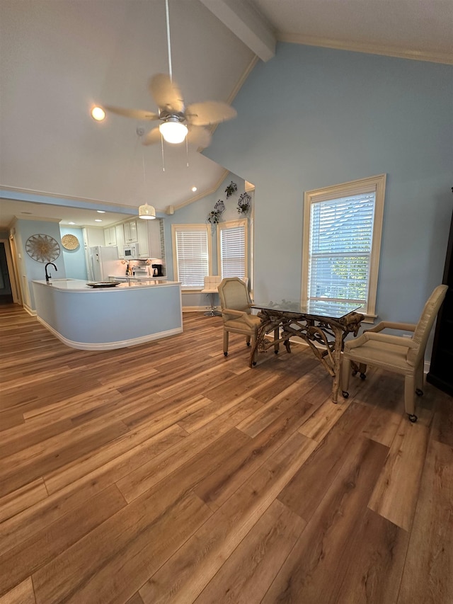 living area featuring lofted ceiling with beams, ceiling fan, and hardwood / wood-style flooring