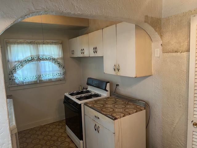 kitchen with white cabinets and white range with gas stovetop