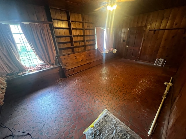 unfurnished room with wooden walls and ceiling fan