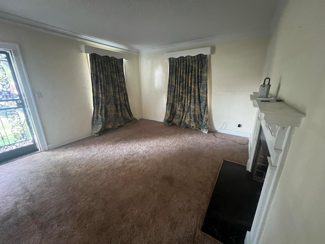 spare room with a fireplace, carpet flooring, and crown molding