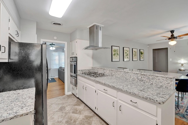 kitchen featuring white cabinets, kitchen peninsula, stainless steel appliances, ventilation hood, and light wood-type flooring