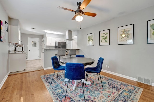 dining room with ceiling fan, sink, and light hardwood / wood-style floors