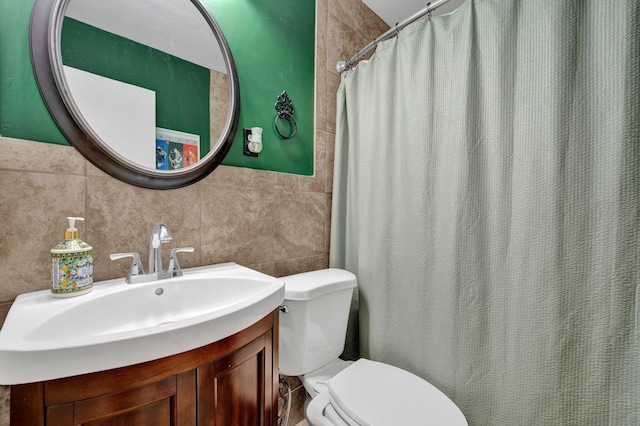 bathroom featuring curtained shower, tile walls, vanity, and toilet