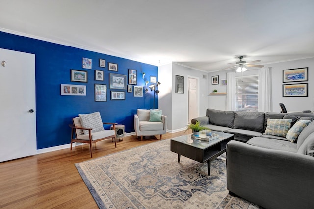 living room featuring wood-type flooring, ceiling fan, and crown molding