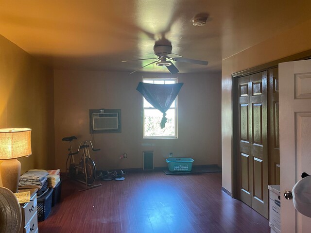 miscellaneous room with a wall mounted AC, ceiling fan, and dark wood-type flooring