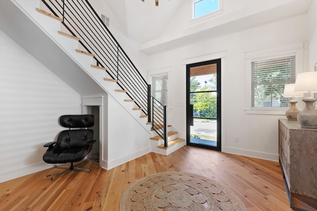 entrance foyer with light hardwood / wood-style flooring and a towering ceiling