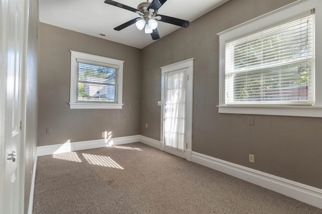 carpeted spare room featuring ceiling fan