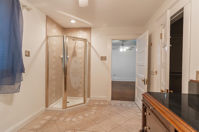 bathroom with a shower with door, tile patterned floors, vanity, and ceiling fan