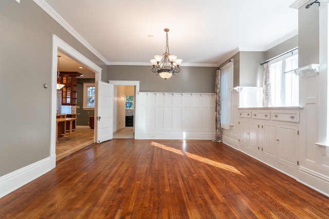 unfurnished dining area featuring ornamental molding, hardwood / wood-style floors, and a chandelier