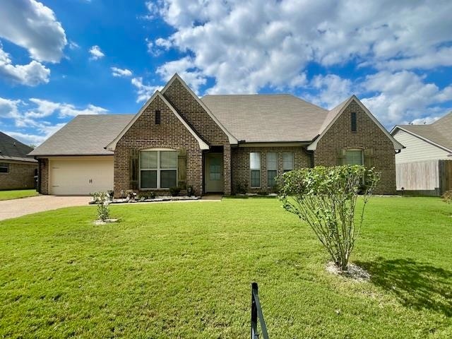 view of front of property with a front lawn and a garage