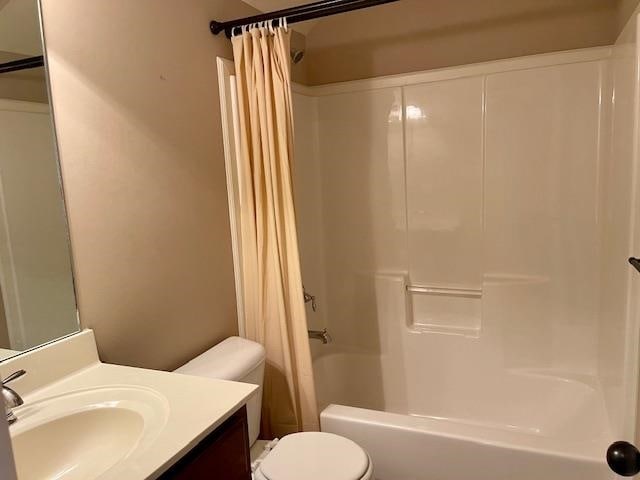 full bathroom with vanity, shower / bath combo with shower curtain, and toilet