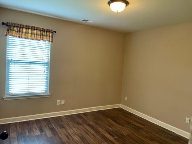 unfurnished room with dark wood-type flooring