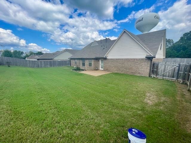 back of house with a patio and a yard