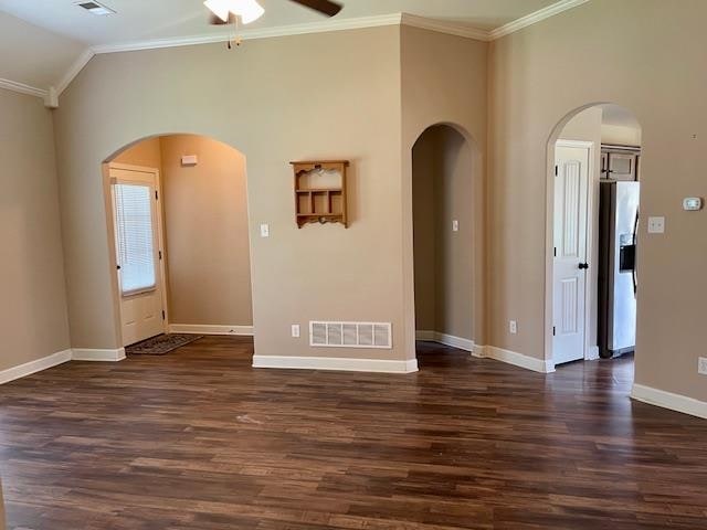 unfurnished room with ornamental molding, dark hardwood / wood-style floors, ceiling fan, and vaulted ceiling