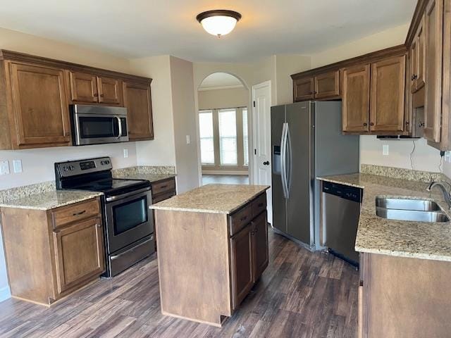 kitchen with light stone counters, stainless steel appliances, dark hardwood / wood-style floors, and sink