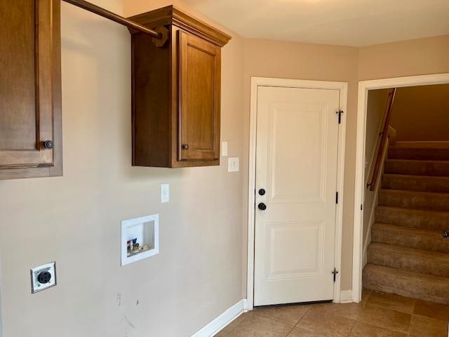 laundry area featuring light tile patterned floors, washer hookup, electric dryer hookup, and cabinets