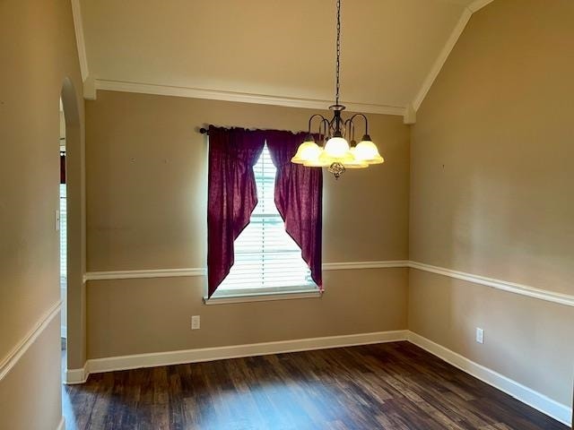 unfurnished room with an inviting chandelier, crown molding, lofted ceiling, and dark hardwood / wood-style floors