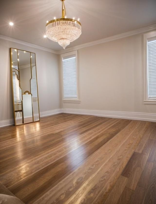 unfurnished room with a notable chandelier, a healthy amount of sunlight, crown molding, and dark wood-type flooring