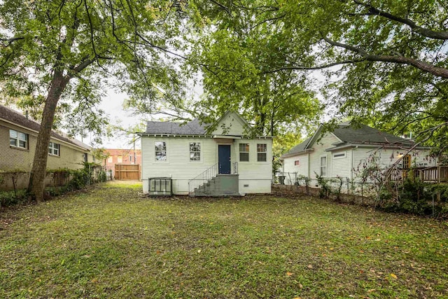 back of house with a lawn and central AC