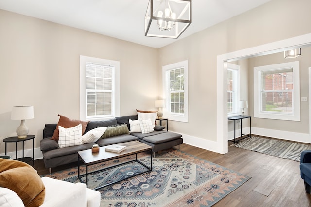 living room featuring an inviting chandelier and dark wood-type flooring