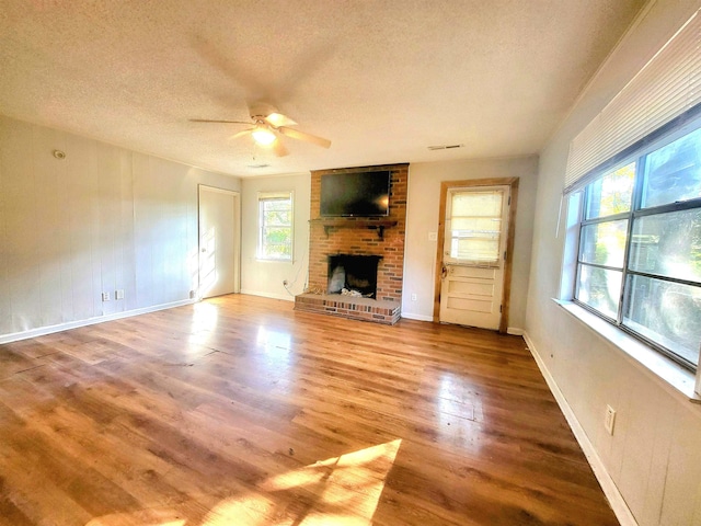 unfurnished living room with wood-type flooring, ceiling fan, and a textured ceiling