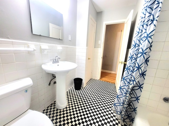 bathroom featuring tile walls and toilet