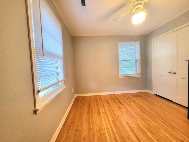 unfurnished bedroom with multiple windows, ceiling fan, and light hardwood / wood-style flooring