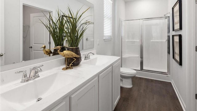 bathroom with hardwood / wood-style floors, walk in shower, vanity, and toilet