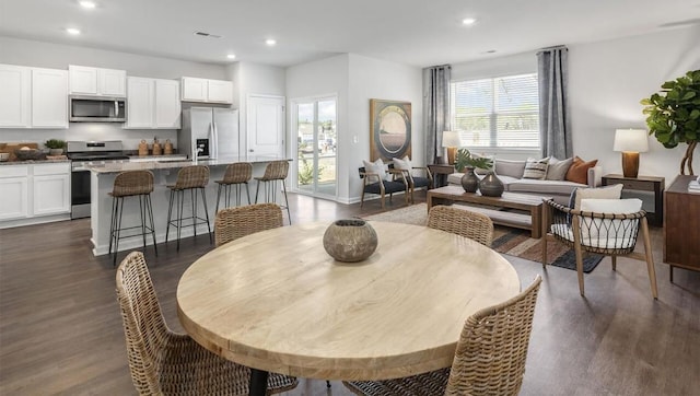 dining room featuring a wealth of natural light, visible vents, dark wood-style flooring, and recessed lighting