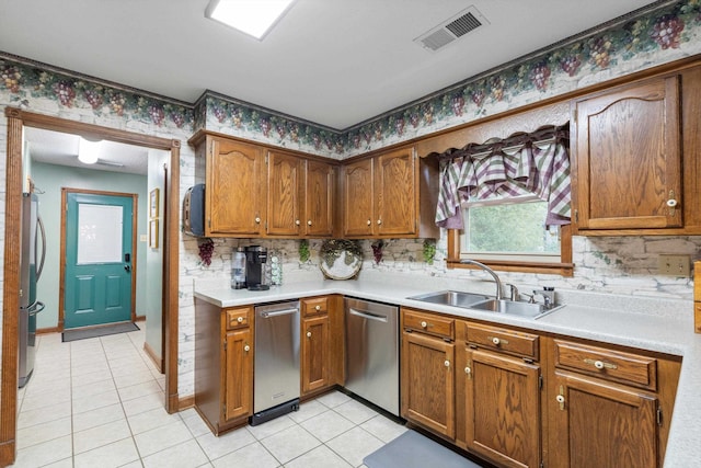 kitchen with light tile patterned floors, appliances with stainless steel finishes, sink, and tasteful backsplash