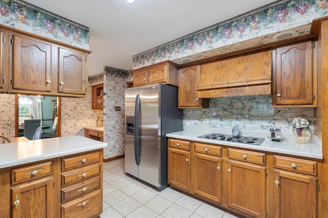 kitchen featuring premium range hood, stainless steel refrigerator with ice dispenser, white gas stovetop, and light tile patterned floors