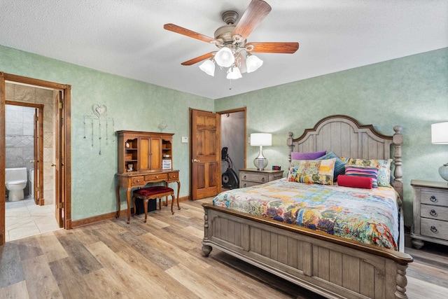 bedroom with ceiling fan, a textured ceiling, light wood-type flooring, and ensuite bathroom