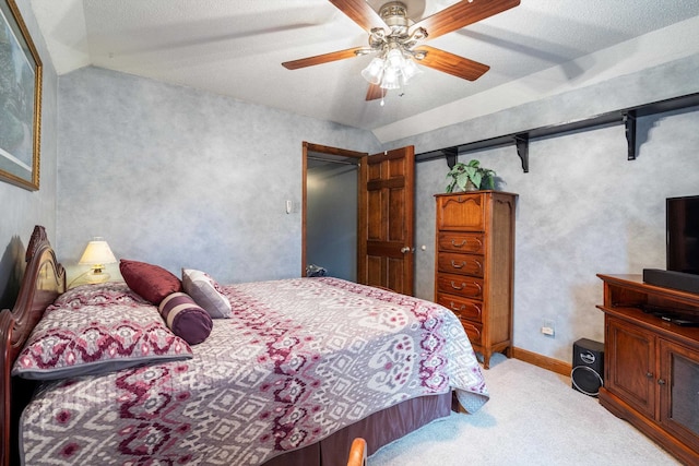 carpeted bedroom with a textured ceiling, vaulted ceiling, and ceiling fan