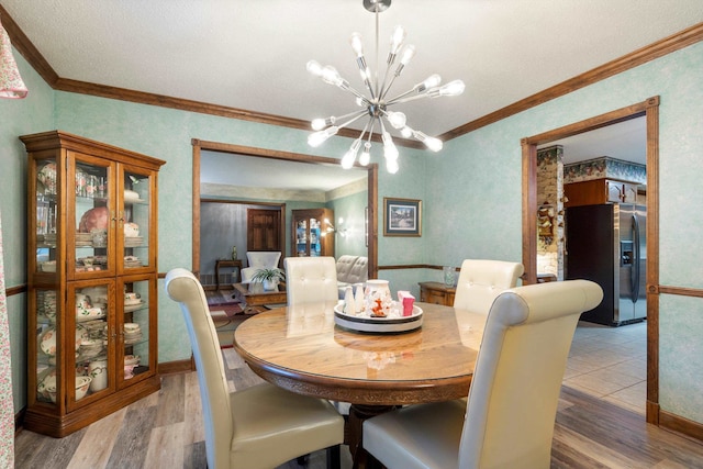 dining area featuring ornamental molding, an inviting chandelier, and hardwood / wood-style flooring