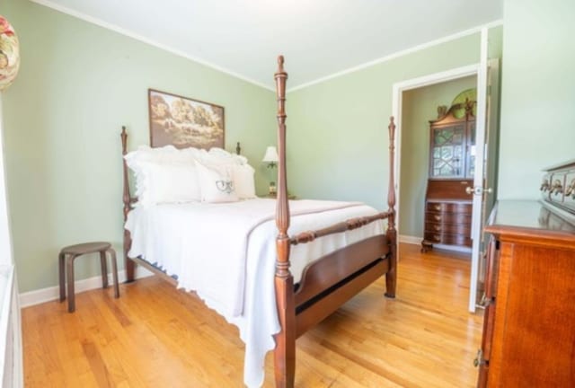 bedroom featuring light wood-type flooring and crown molding