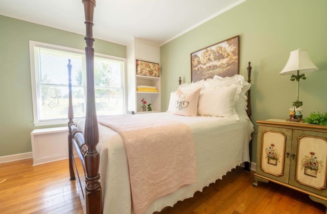 bedroom featuring light hardwood / wood-style floors and crown molding