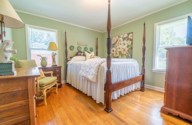 bedroom with light hardwood / wood-style flooring, multiple windows, and ornamental molding