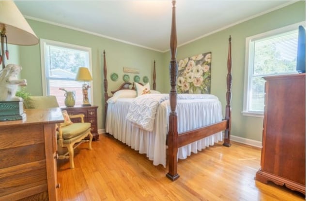 bedroom featuring light wood-type flooring and crown molding