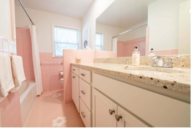 full bathroom with tile walls, shower / tub combo with curtain, vanity, and toilet