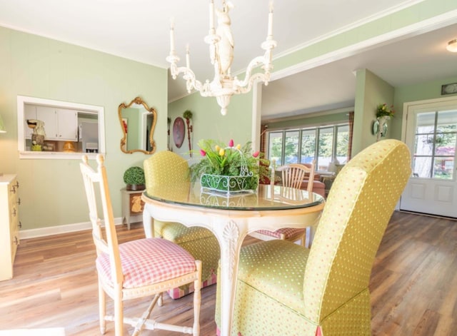 dining space with a chandelier, hardwood / wood-style floors, and crown molding